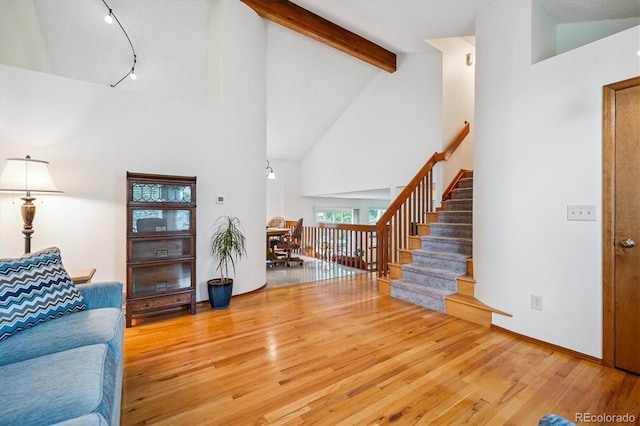 5513 S Yank Ct, Littleton, CO 80127 - living room featuring high vaulted ceiling, wood finished floors, beam ceiling, stairs, and track lighting
