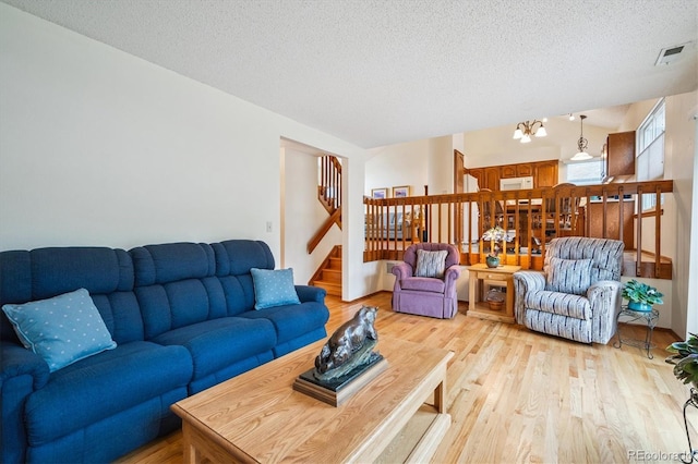 5513 S Yank Ct, Littleton, CO 80127 - living room with stairway, light wood-style floors, and a textured ceiling