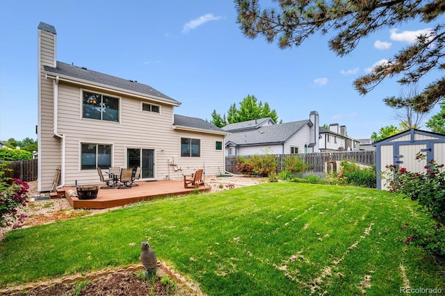 5513 S Yank Ct, Littleton, CO 80127 - back of house with a storage shed, a fenced backyard, a wooden deck, and a chimney