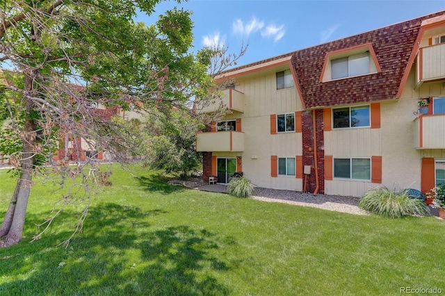 10211 Ura Ln Unit 208, Thornton, CO 80260 - back of property featuring a shingled roof and a lawn