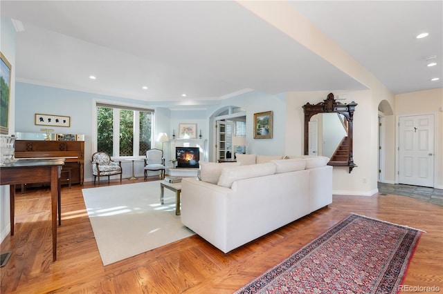 living room with crown molding and light hardwood / wood-style flooring