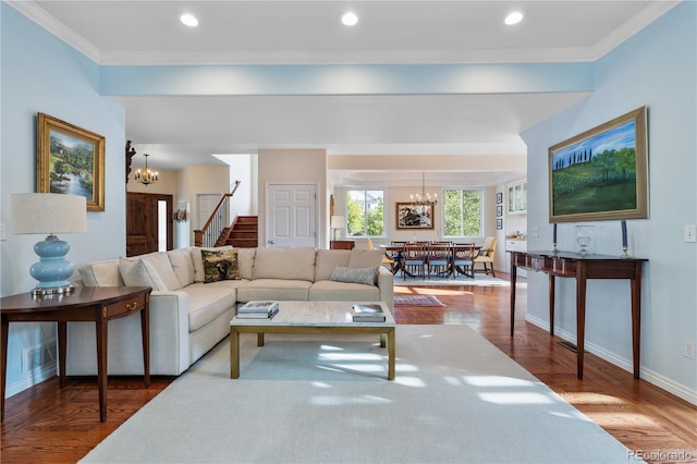 living room featuring crown molding, hardwood / wood-style floors, and an inviting chandelier