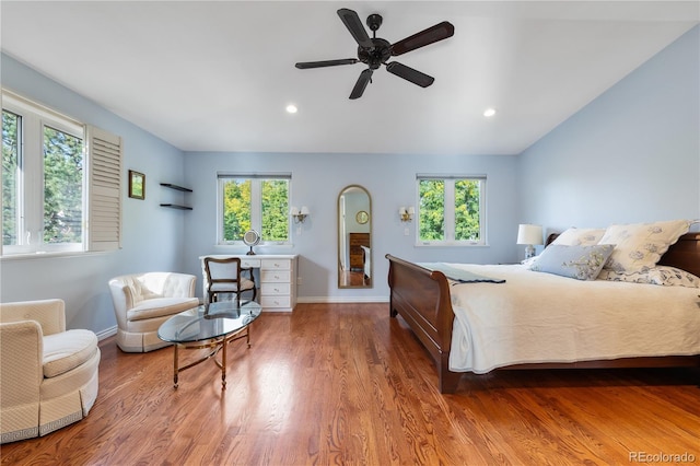 bedroom featuring multiple windows, lofted ceiling, and hardwood / wood-style floors