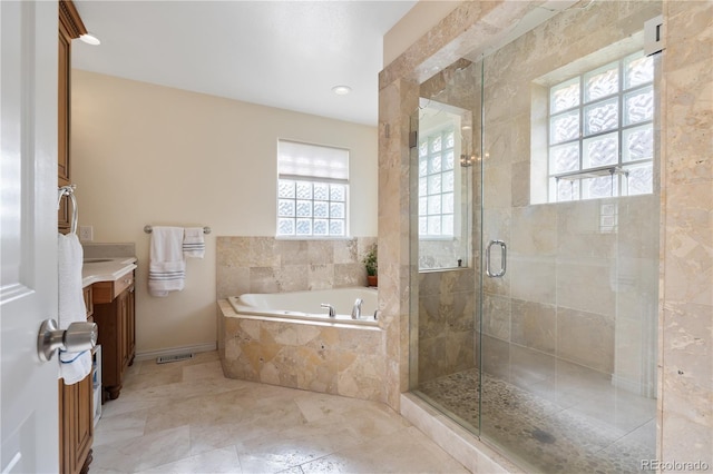 bathroom with vanity and shower with separate bathtub