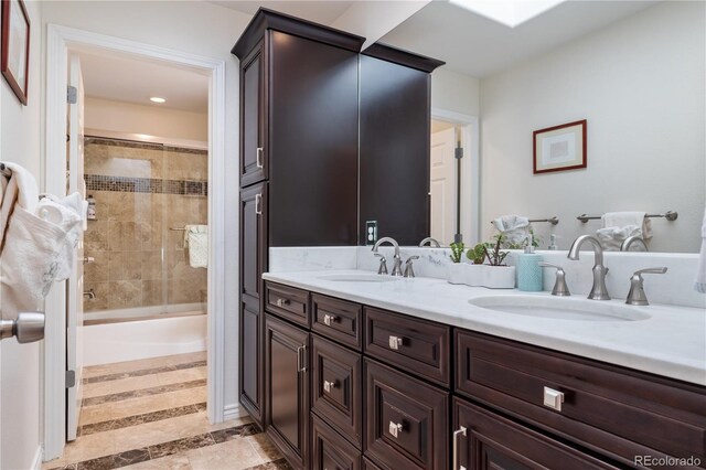 bathroom featuring vanity, shower / bath combination with glass door, and a skylight