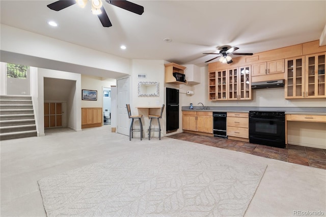 kitchen with light brown cabinetry, sink, black appliances, and carpet flooring