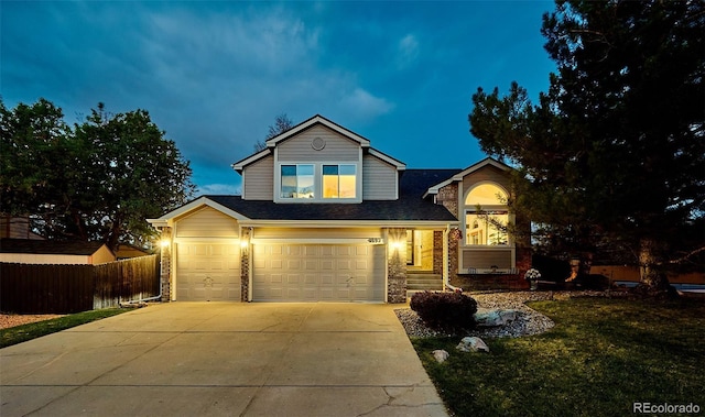 traditional home featuring fence, stone siding, a garage, a front yard, and driveway