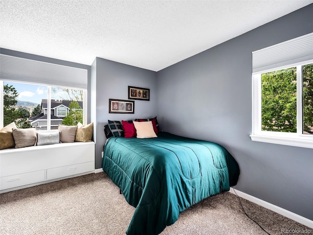 bedroom with baseboards, multiple windows, and carpet