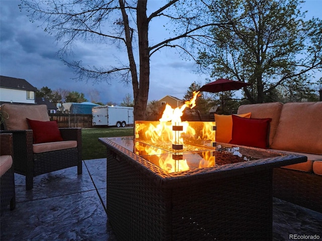 view of patio featuring an outdoor fire pit and fence
