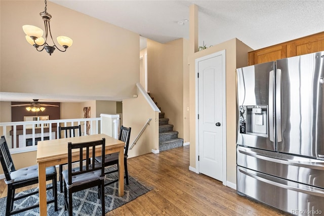 dining room featuring ceiling fan with notable chandelier and hardwood / wood-style floors