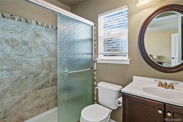 bathroom featuring vanity, toilet, and a shower with door