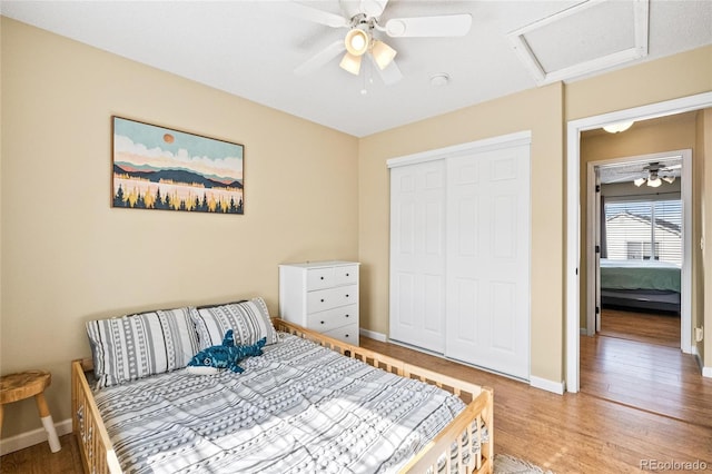 bedroom with hardwood / wood-style floors, ceiling fan, and a closet