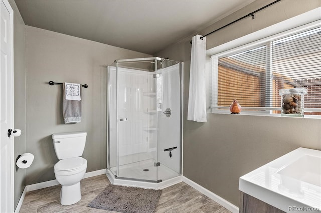 bathroom with a shower with door, vanity, hardwood / wood-style floors, and toilet