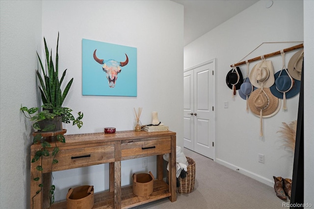 hallway with carpet floors and baseboards