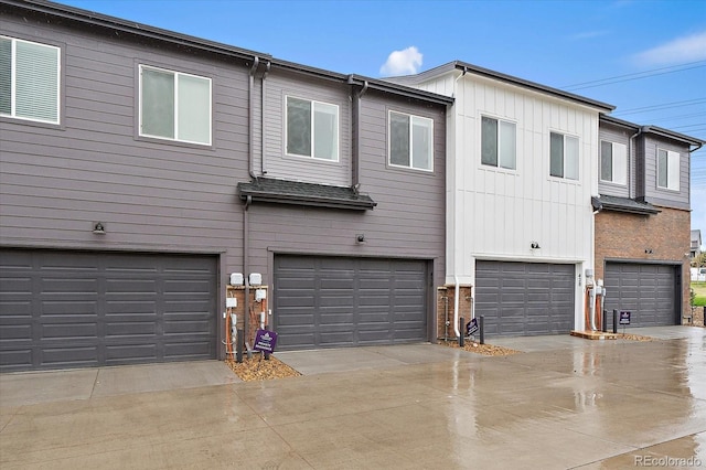 view of front of house featuring board and batten siding, a garage, and concrete driveway