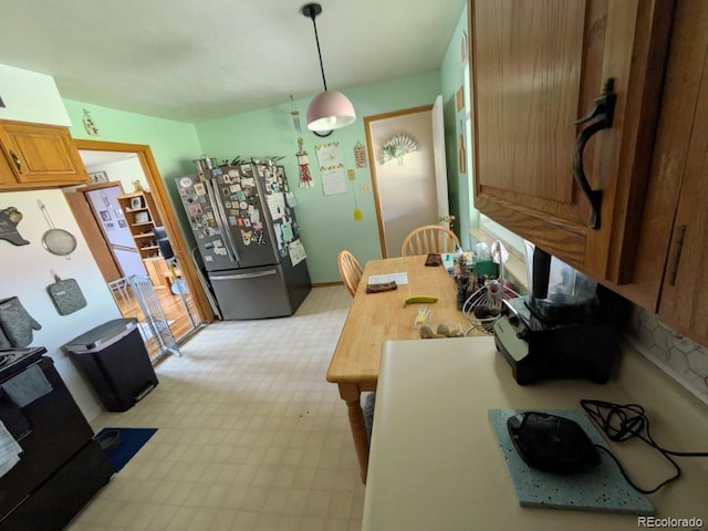 290 W 1st Ave, Broomfield, CO 80020 - kitchen with freestanding refrigerator, hanging light fixtures, stove, light flooring, and brown cabinets