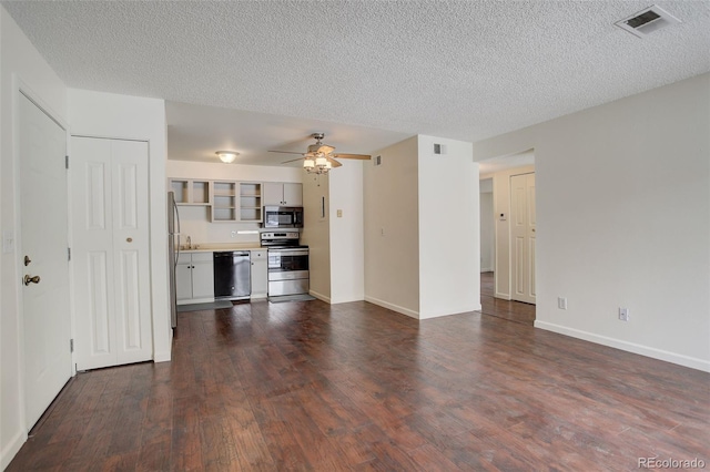 unfurnished living room with a textured ceiling, dark hardwood / wood-style flooring, and ceiling fan