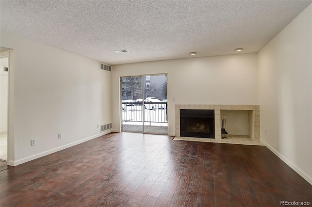 unfurnished living room with a fireplace, hardwood / wood-style floors, and a textured ceiling