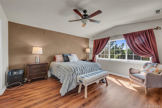 bedroom with vaulted ceiling, hardwood / wood-style flooring, and ceiling fan