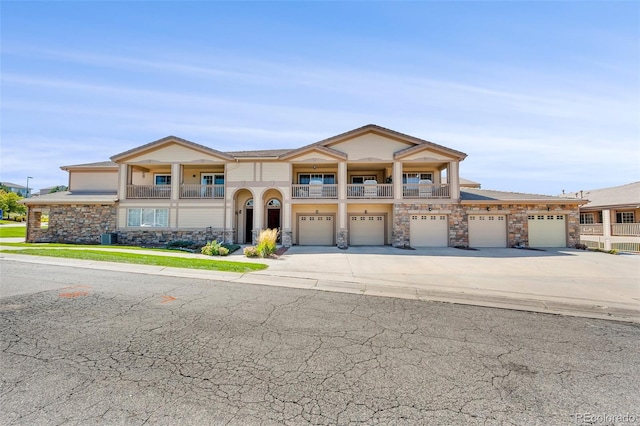 view of front of home featuring a balcony, a garage, and central AC unit