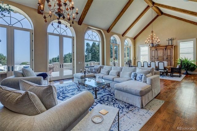 living room with a healthy amount of sunlight, dark wood-type flooring, french doors, high vaulted ceiling, and a chandelier