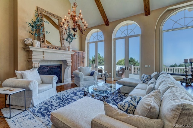 living room with wood-type flooring, beamed ceiling, a high ceiling, a premium fireplace, and french doors