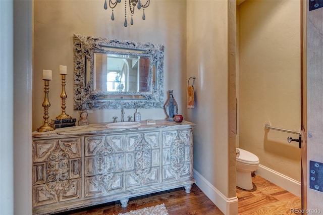 bathroom featuring toilet, vanity, and hardwood / wood-style floors