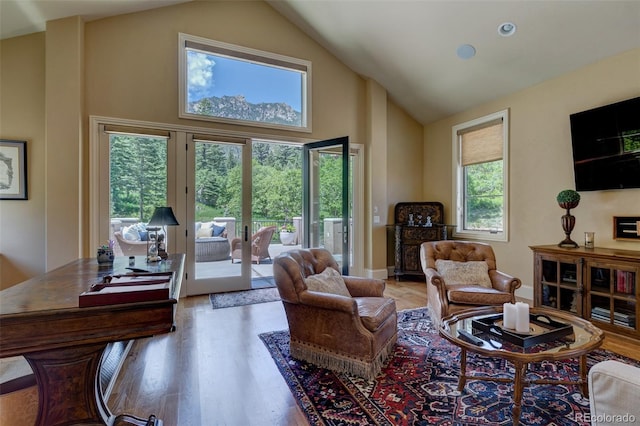 living room featuring french doors, hardwood / wood-style flooring, and high vaulted ceiling