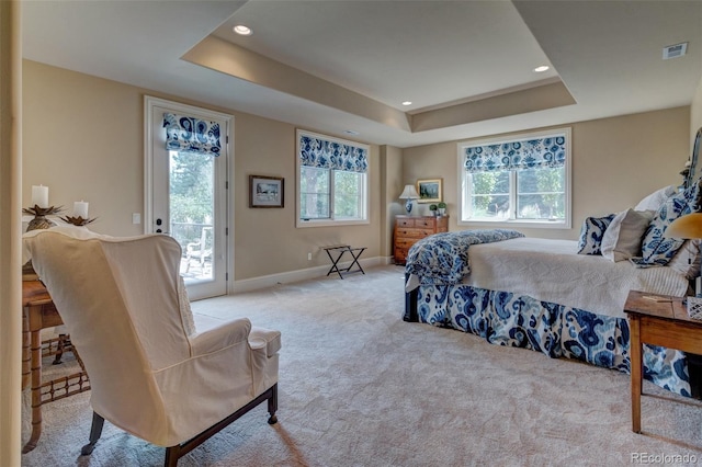 carpeted bedroom with a tray ceiling and access to outside