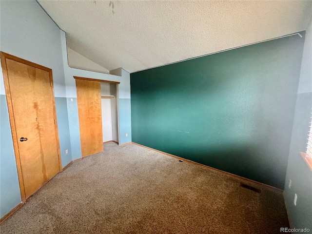 10064 Westside Cir, Littleton, CO 80125 - unfurnished bedroom featuring vaulted ceiling, carpet floors, and a textured ceiling