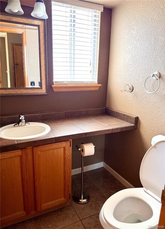 10064 Westside Cir, Littleton, CO 80125 - half bathroom with vanity, tile patterned floors, and a textured wall