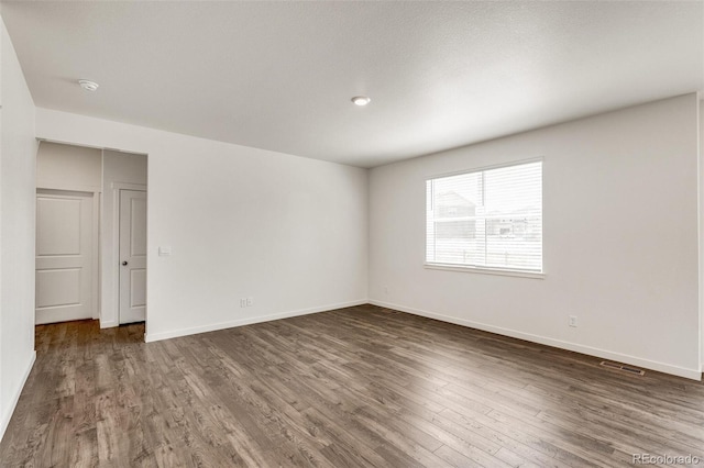 spare room with dark hardwood / wood-style flooring