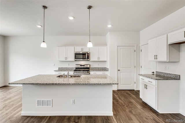 kitchen with white cabinetry, appliances with stainless steel finishes, an island with sink, and hanging light fixtures