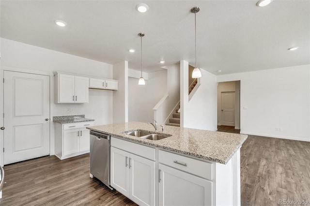 kitchen featuring white cabinetry, decorative light fixtures, stainless steel dishwasher, and a center island with sink