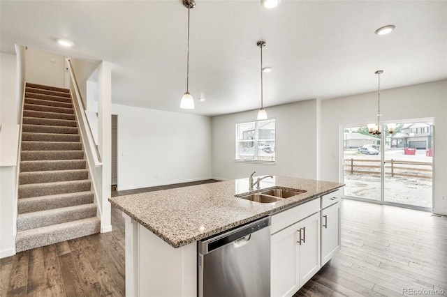 kitchen with pendant lighting, dishwasher, sink, white cabinets, and light stone countertops