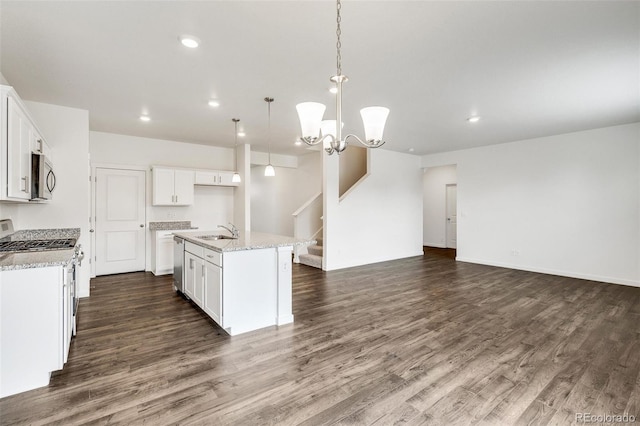 kitchen with white cabinetry, appliances with stainless steel finishes, a center island with sink, and decorative light fixtures