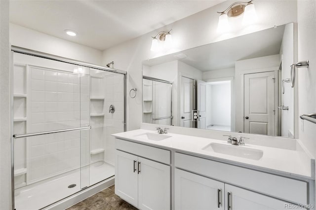 bathroom featuring a shower with door and vanity