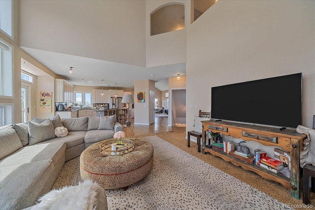 living room featuring a towering ceiling and baseboards