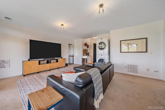 living area with light carpet, stacked washer and clothes dryer, and visible vents