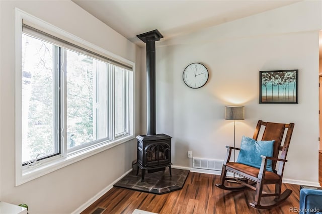 7256 Aspen Meadow Dr, Evergreen, CO 80439 - sitting room with a wood stove, plenty of natural light, dark wood-style flooring, and lofted ceiling
