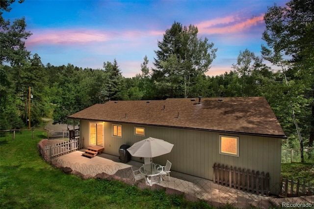 7256 Aspen Meadow Dr, Evergreen, CO 80439 - back of house at dusk featuring a patio and a shingled roof