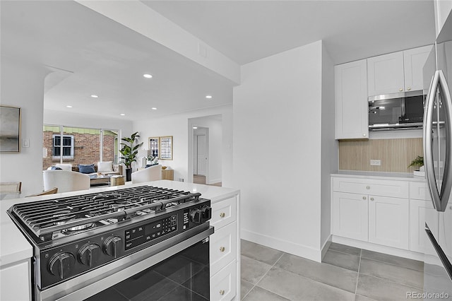 kitchen with baseboards, recessed lighting, stainless steel appliances, light countertops, and white cabinetry