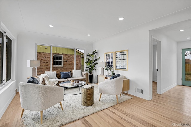 living room with visible vents, recessed lighting, light wood-type flooring, and baseboards