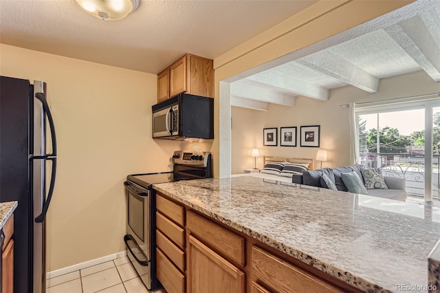 kitchen with light stone counters, beamed ceiling, light tile patterned floors, a textured ceiling, and black appliances