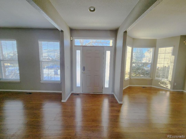 foyer entrance featuring hardwood / wood-style floors and a textured ceiling