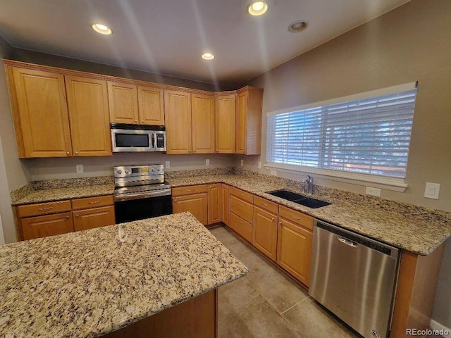 kitchen with light stone countertops, sink, and appliances with stainless steel finishes