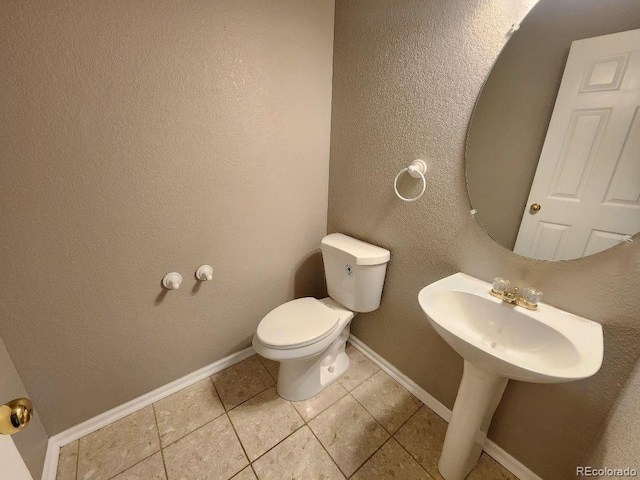 bathroom featuring toilet and tile patterned flooring