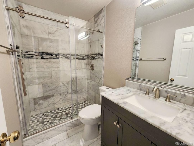 bathroom with an enclosed shower, vanity, and toilet