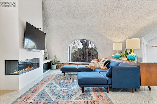 6681 S Abilene Way, Centennial, CO 80111 - living area featuring a glass covered fireplace, visible vents, and speckled floor