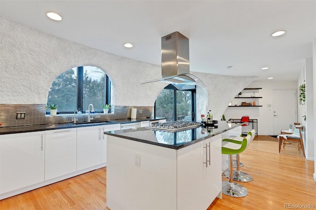 6681 S Abilene Way, Centennial, CO 80111 - kitchen with a healthy amount of sunlight, stainless steel gas stovetop, a sink, and island exhaust hood
